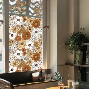 Detail of floral window film with orange daisies providing privacy on cafe glass