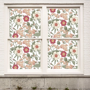 Detailed view of floral window film with pink flowers and green leaves on glass panes