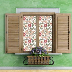 Close-up of floral window film with pink flowers and green leaves on glass