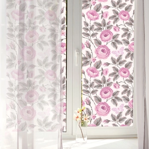 Detail of floral window film showing pink roses, grey leaves, and butterflies for privacy