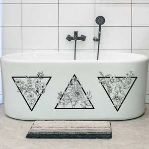 Detail of waterproof black floral triangle wall decals applied on a white bathtub surface