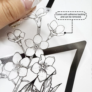 Close-up showing the transparency and adhesive backing of the black and white floral wall sticker