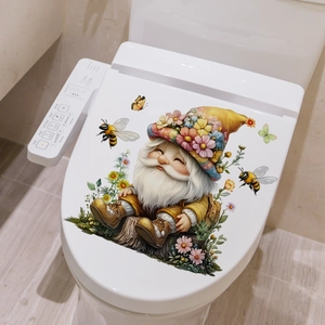 Detail of garden gnome and bumblebee sticker on a white modern toilet seat cover