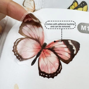 Macro shot of a semi-transparent pink butterfly wall sticker with adhesive backing