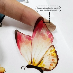 Close-up showing the transparent adhesive backing on a butterfly-shaped wall decal
