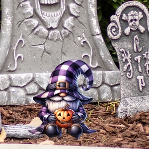 Detail of Halloween gnome with purple plaid hat holding a carved pumpkin lantern