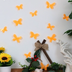 Detailed view of 3D orange translucent butterfly wall stickers on a clean white wall
