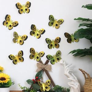 Detail of 3D gold butterfly wall stickers with glitter wings on a white wall