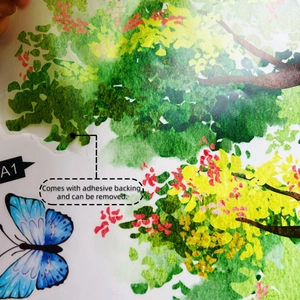 Detail of watercolor tree branch and blue butterfly wall sticker with adhesive backing
