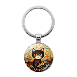 Vista detallada del llavero metálico redondo con ilustración de gato negro y flores