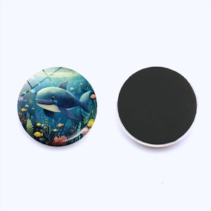 Detail of round glass magnet with blue whale ocean illustration and full magnetic backing
