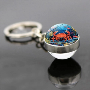 Détail macro d'un porte-clés dôme en verre avec motif de crabe coloré et coraux marins