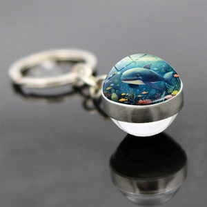 Macro d'un porte-clés boule de verre avec illustration de requin bleu et anneau poli