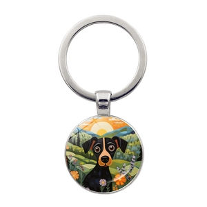 Detailed view of silver dog keychain pendant with colorful sunset landscape illustration
