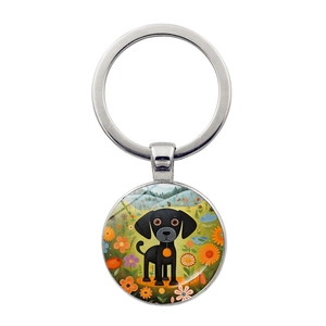 Detailed close-up of a silver keychain with an artistic black dog cartoon illustration