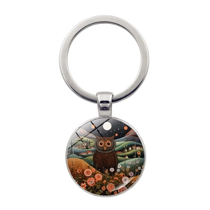 Detailed view of an owl art pendant keychain with vibrant forest and night sky illustration