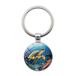 Macro detail of round glass cabochon keychain featuring a sea turtle underwater illustration