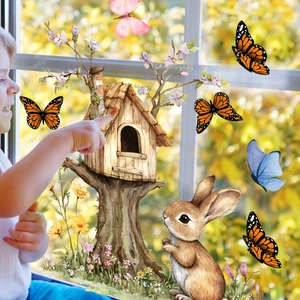 Détail des stickers de Pâques lapin et cabane sur vitre avec vue sur le jardin en arrière