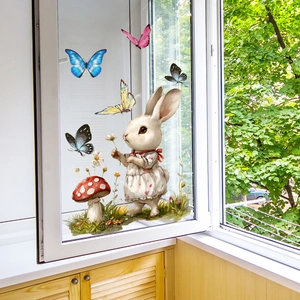 Détail de stickers fenêtre lapin et papillons sur une vitre lumineuse avec vue jardin