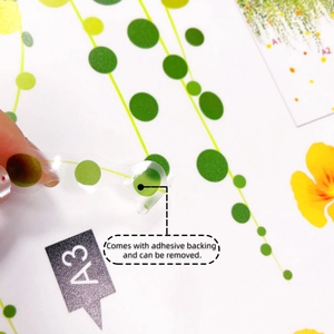 Detail of peeling green vine wall sticker showing adhesive backing and removable PVC material