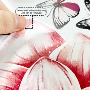Détail du décollage d'un autocollant mural papillon coloré montrant le support adhésif