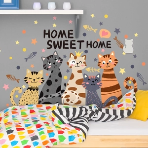 Cozy bedroom scene featuring cartoon cat wall stickers and Home Sweet Home lettering