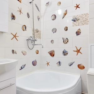 Colorful sea shell and starfish wall decals applied on bathroom tiles for nautical decor