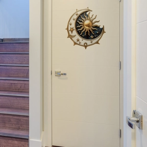 Artistic sun and moon wall sticker featuring golden celestial design on white interior door