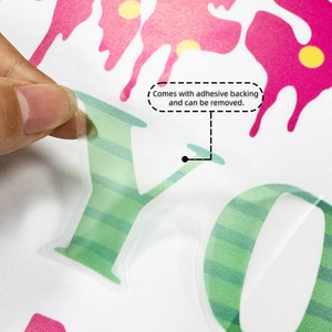 Detail of self-adhesive wall sticker showing peelable backing and striped letter design