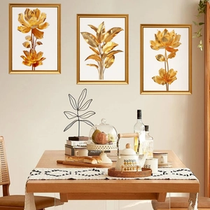 Three-piece set of golden tropical leaf wall art prints with elegant metallic frames
