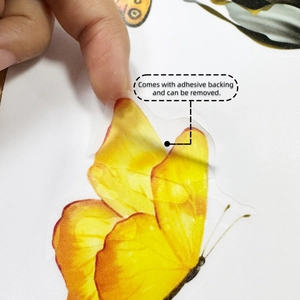 Close-up showing the removable adhesive backing of yellow butterfly wall stickers