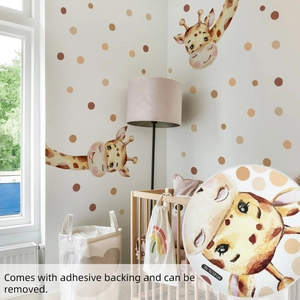 Nursery corner showing cartoon giraffe and polka dot wall decals on a cream wall