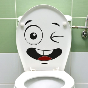 Funny cartoon smiling face sticker on white toilet lid with minimalist bathroom background