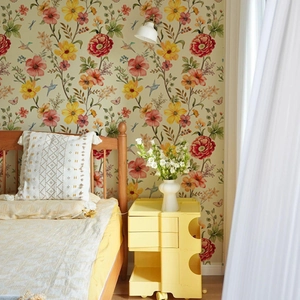Three-tier yellow modular bedside storage cabinet with floral wallpaper in a cozy bedroom