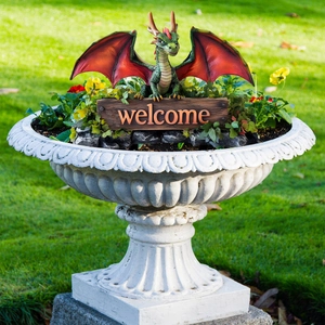 Garden welcome dragon stake with green scales and red wings in a decorative flower pot