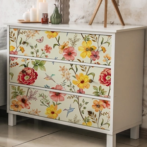 Detail of floral hand-painted wallpaper on a three-drawer cabinet in a cozy bedroom