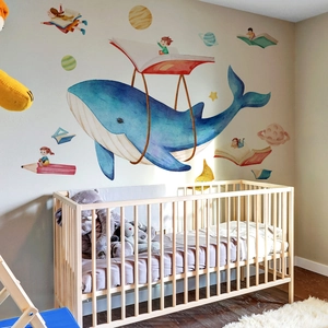 Cartoon whale wall decal with watercolor planets and books for a cozy kids' nursery decor
