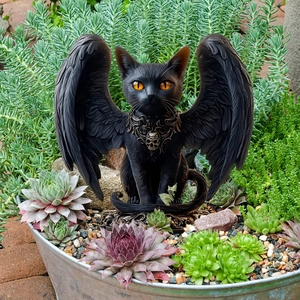 Gothic black winged cat garden stake with skull collar placed among succulents