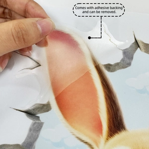Close-up of Easter rabbit toilet sticker with adhesive backing being removed easily