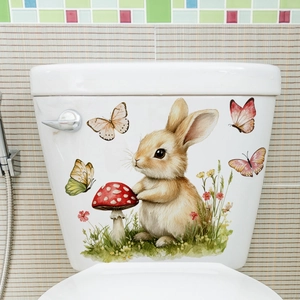 Detail of watercolor bunny and floral stickers applied to a white ceramic toilet tank
