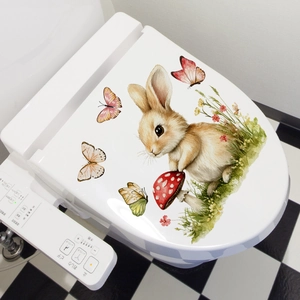 Close-up of Easter rabbit and mushroom watercolor sticker on a white toilet lid