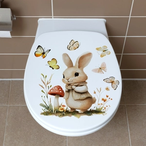 Detailed view of cute Easter bunny and butterfly stickers on a white toilet lid