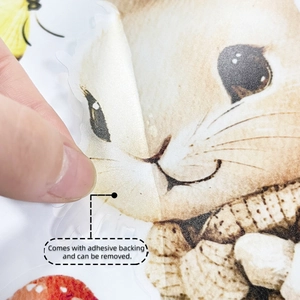 Detail of self-adhesive Easter rabbit and butterfly sticker being peeled by hand