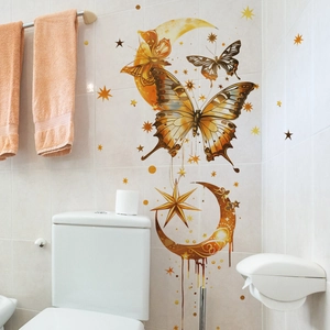 Detail of gold butterfly and moon wall stickers on white tile bathroom wall decor