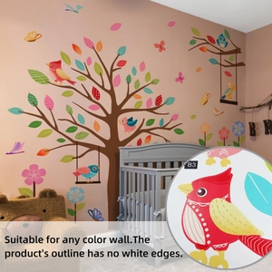 Detail of colorful bird and branch wall decals on a nursery wall with crib scene