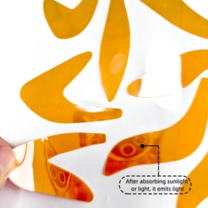 Glow-in-the-dark luminous orange sticker with reflective finish after absorbing light source
