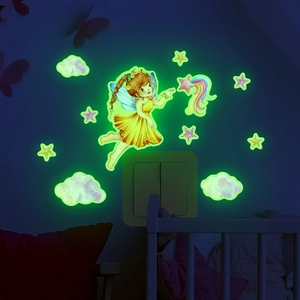 Luminous wall sticker set with a fairy and stars glowing green in a dark bedroom