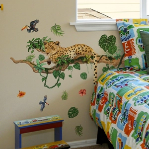 Detail of tropical jungle wall decals with leopard, toucans, and monstera leaves on nursery wall