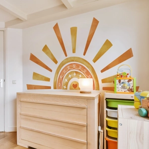 Detail of large watercolor sun and rainbow wall sticker in a bohemian style nursery