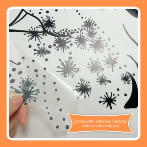Adhesive dandelion and butterfly wall sticker being removed from a clean white surface